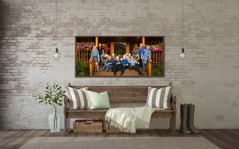 A long framed family portrait on an exposed brick wall above a bench