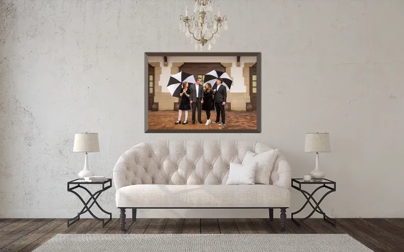 A large framed family portrait hanging above a tufted sofa