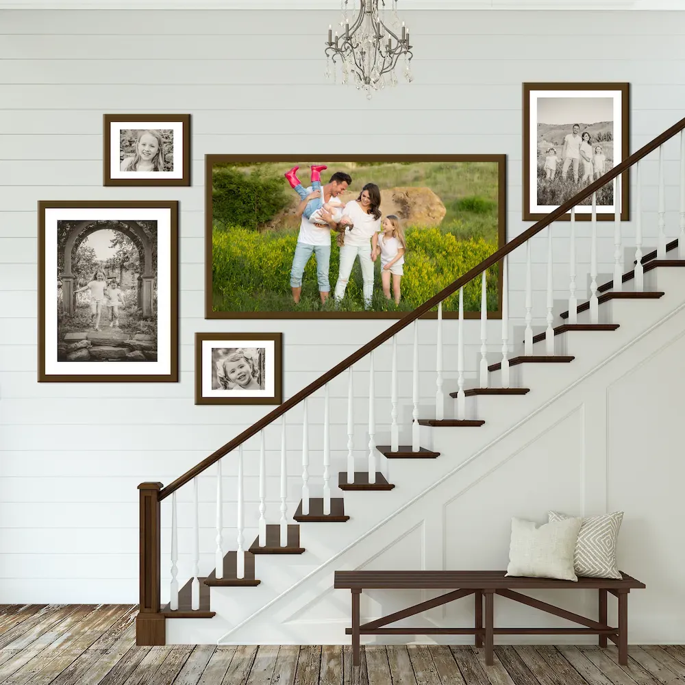 A staircase gallery wall of framed family portraits